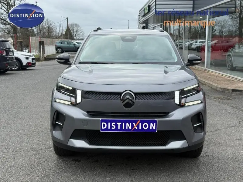 Vue frontale d'une Citroën C3 électrique 2025 en Gris Mercury avec calandre noire et phares LED distinctifs.