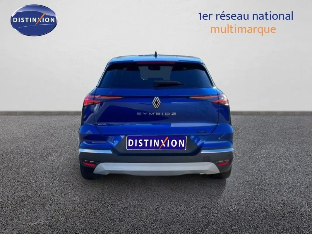 Vue arrière d’un Renault Symbioz bleu 2025 avec feux étirés et logo central bien visible.