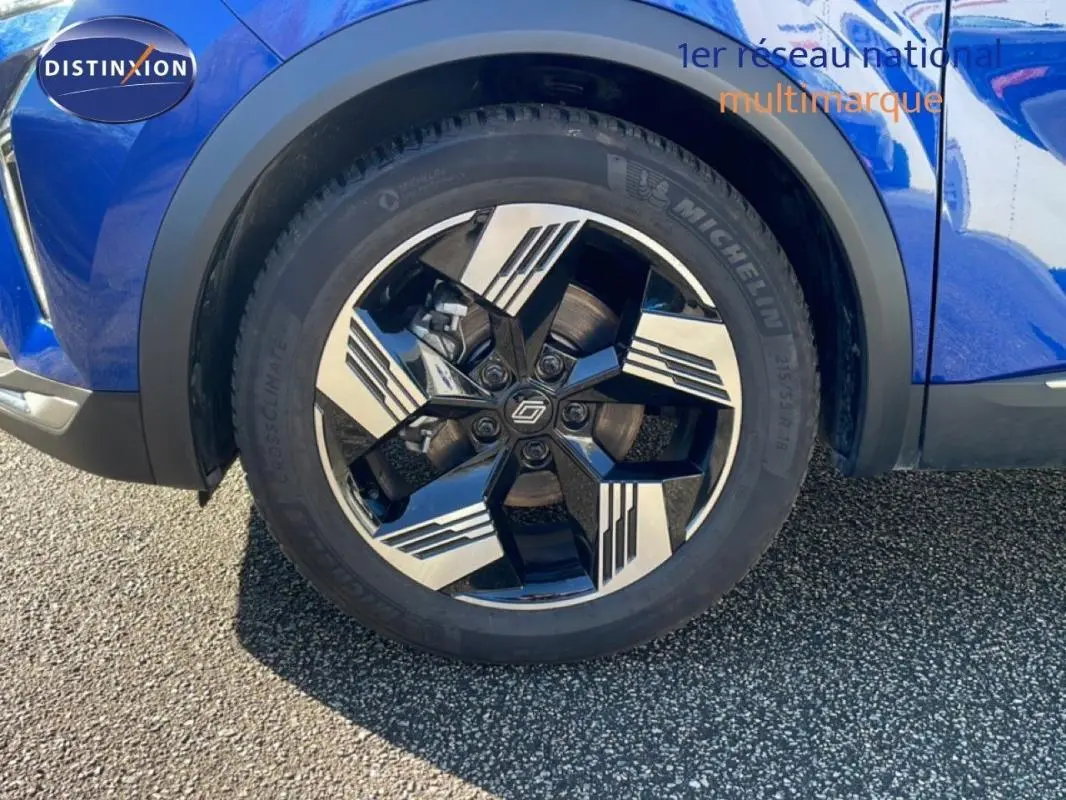 Gros plan sur la jante aluminium noire et argentée du côté avant droit d'une Renault Symbioz bleue.