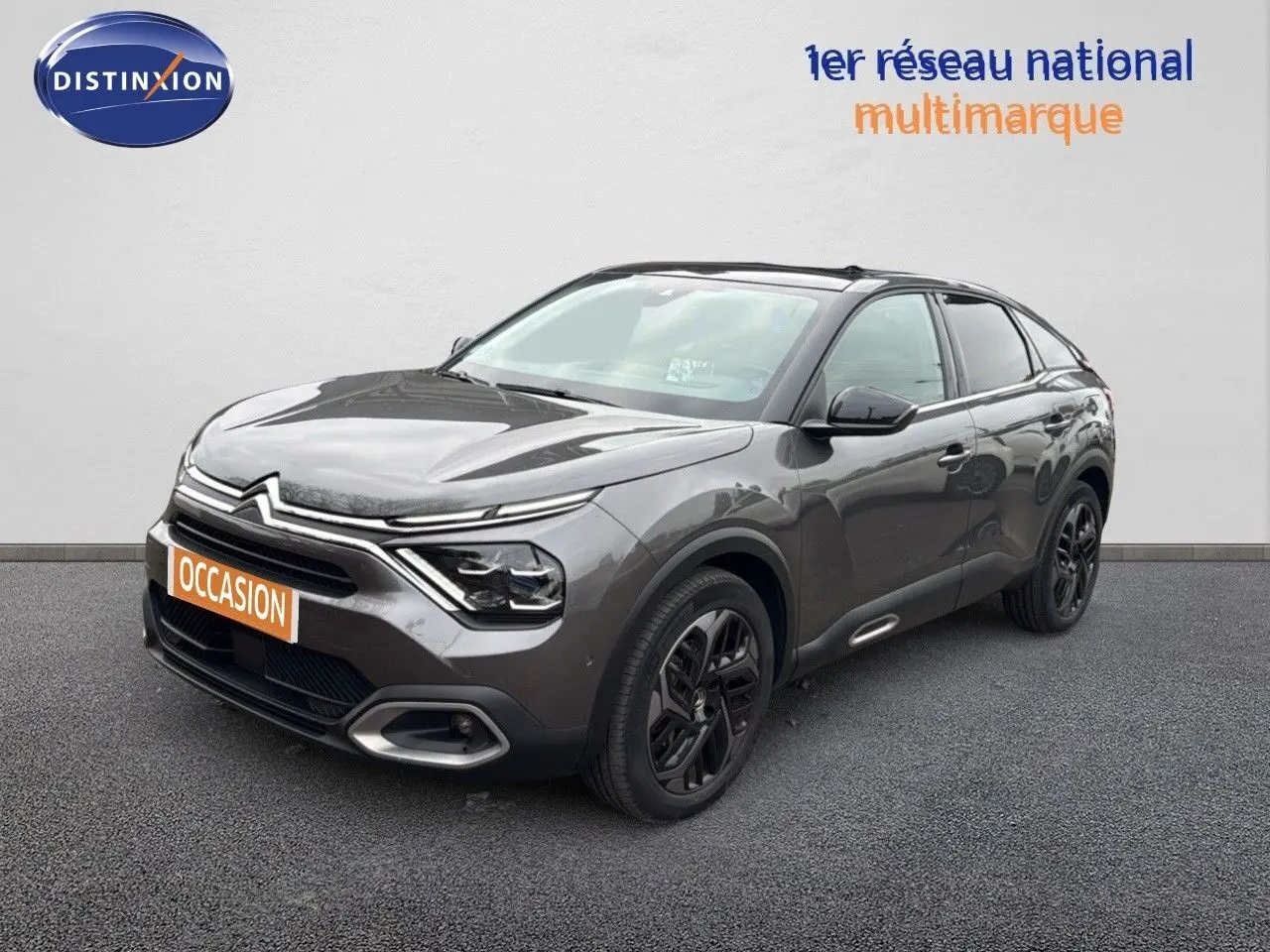 Citroën C4 gris en 3/4 avant droit, avec jantes noires et signature lumineuse LED distinctive.