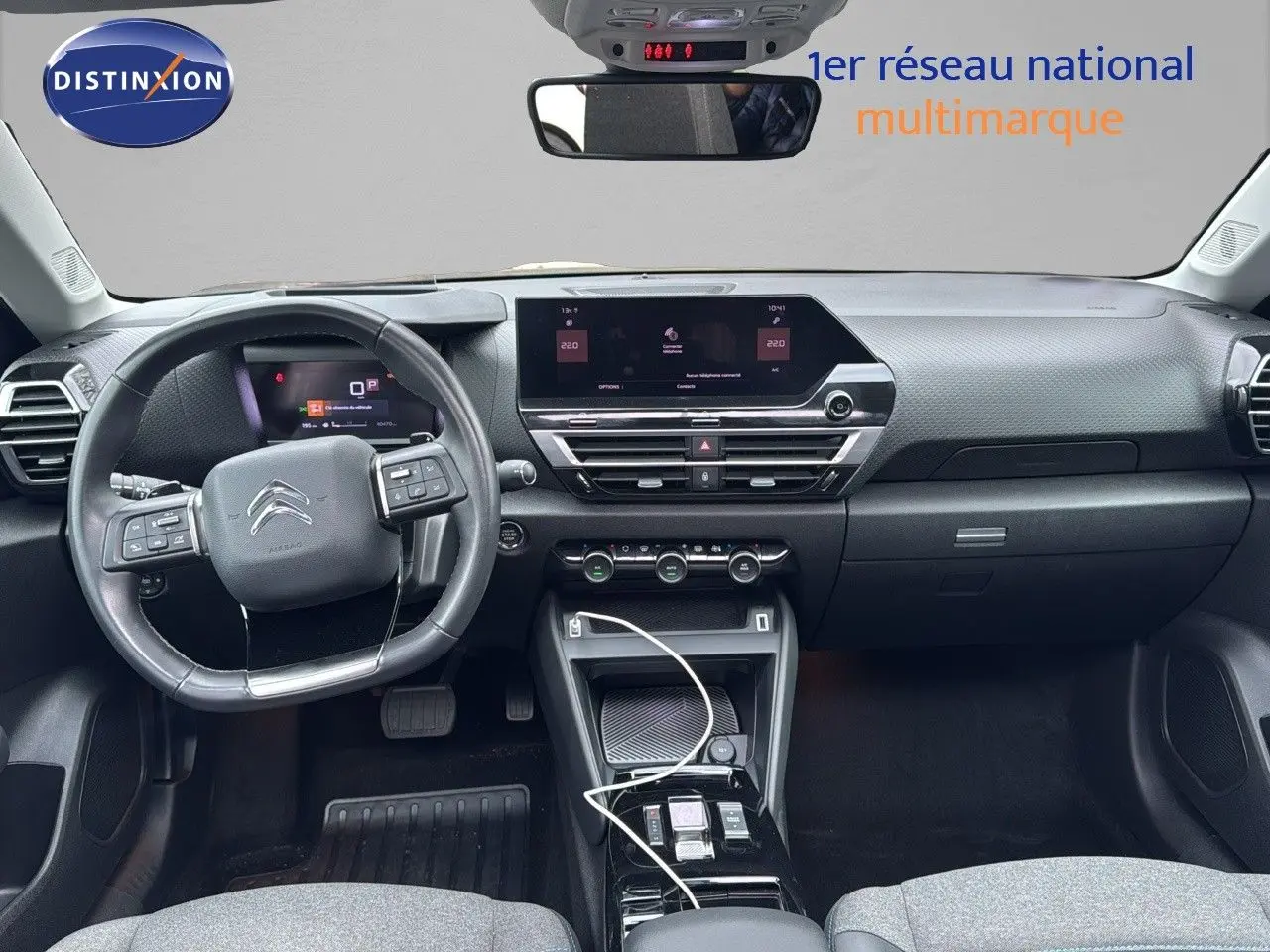 Vue intérieure frontale du tableau de bord gris et noir de la Citroën C4 1.2 PureTech avec écran tactile et volant multifonction.