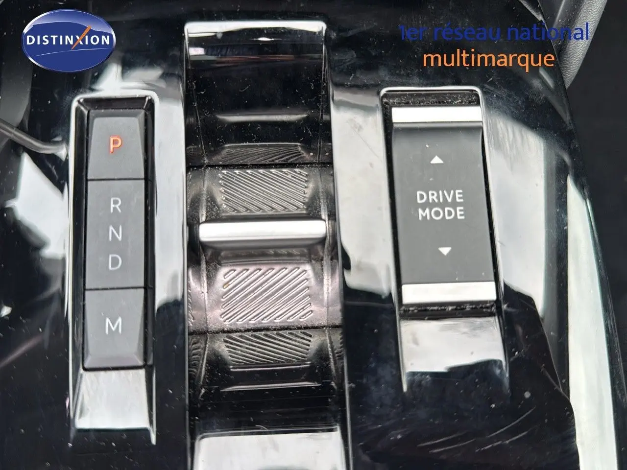 Gros plan sur la console centrale noire brillante de la Citroën C4 1.2 PureTech avec sélecteur de boîte auto et bouton Drive Mode.