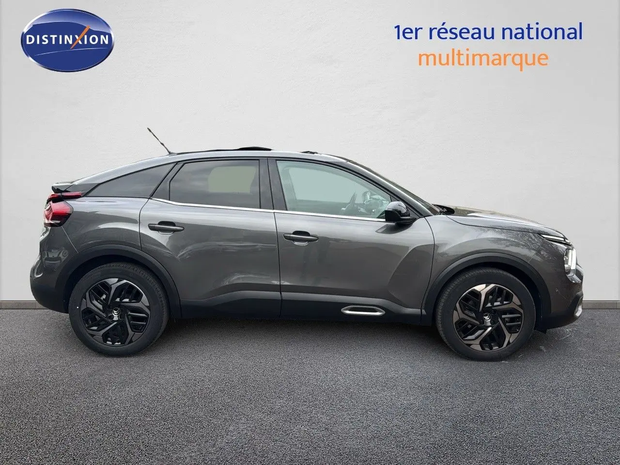 Profil droit d'une Citroën C4 gris métallisé 2021 avec jantes noires bicolores et toit panoramique.