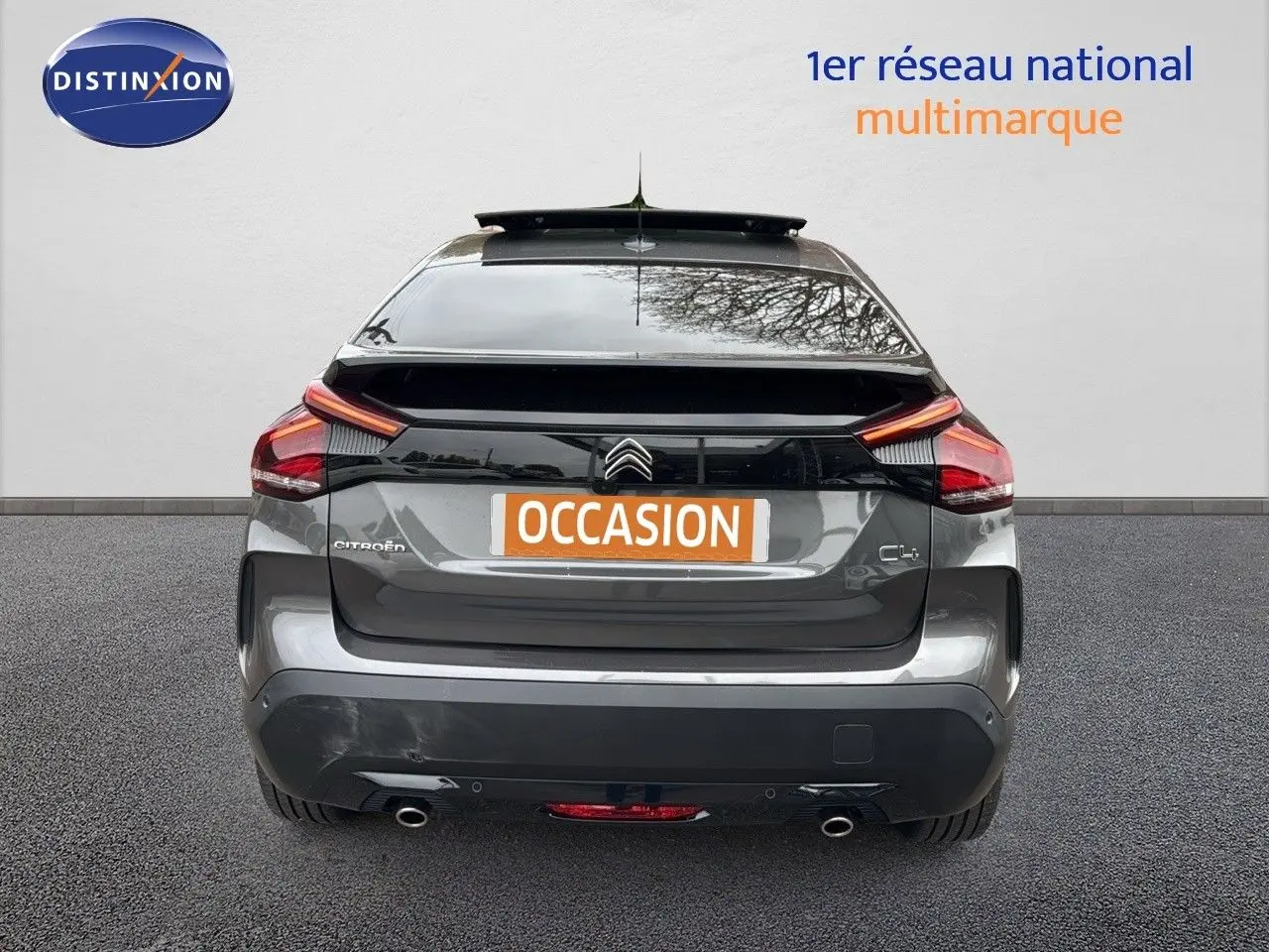 Vue arrière d'une Citroën C4 gris métallisé avec feux LED et double sortie d'échappement visible.