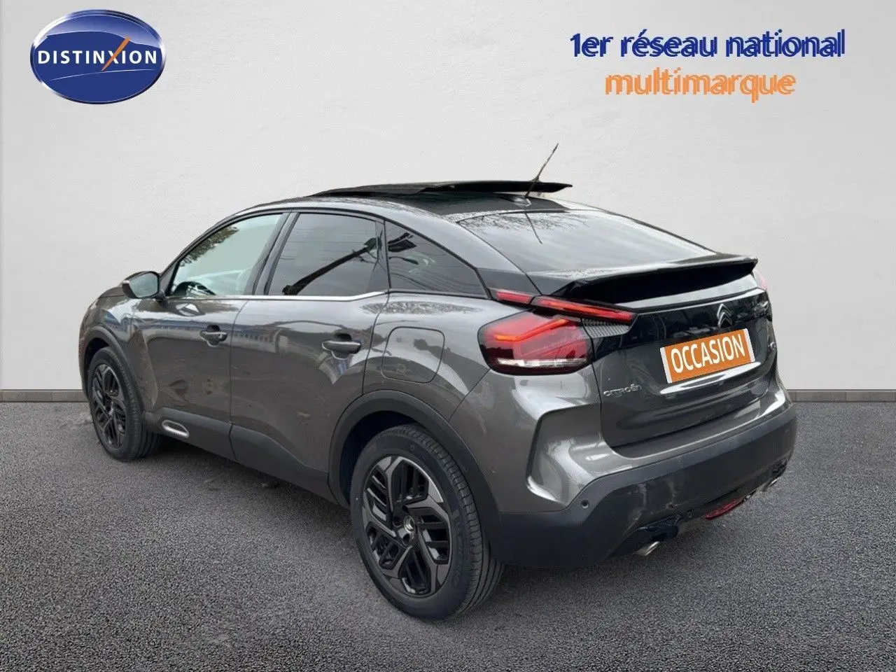 Vue 3/4 arrière droite d'une Citroën C4 gris métallisé avec toit noir et jantes noires biton.