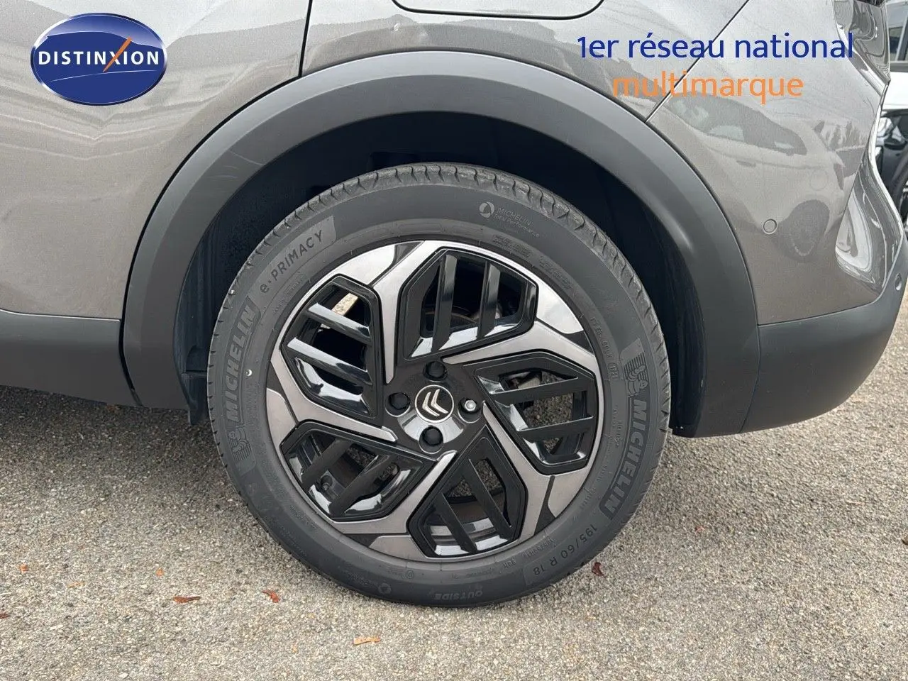 Gros plan sur la roue arrière droite d'une Citroën C4 gris 2021 avec jante alliage bicolore et pneus Michelin.