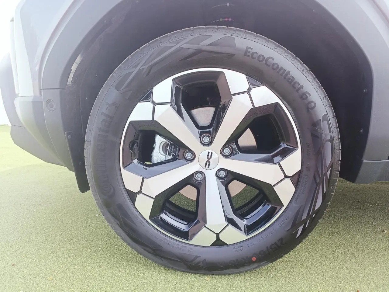 Gros plan sur la jante alliage diamantée 18 pouces noire et argent du Dacia Duster gris schiste.