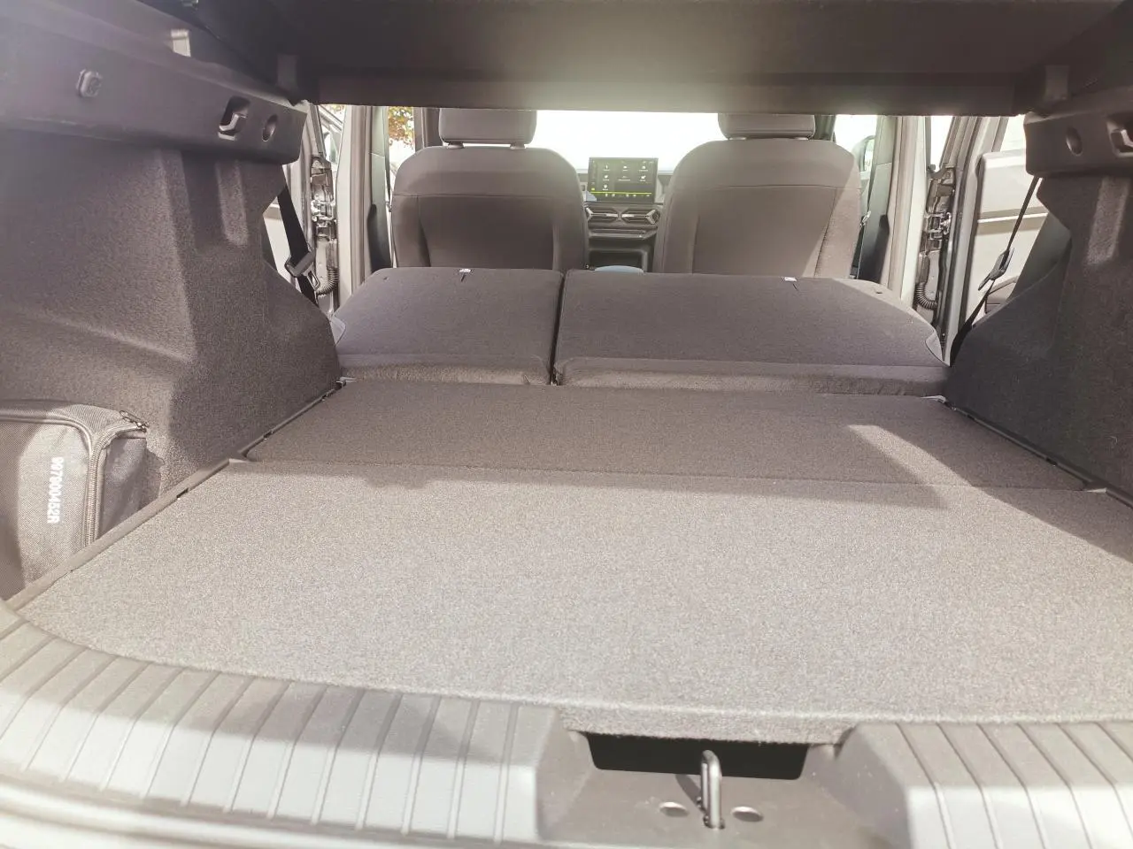 Vue intérieure du coffre du Dacia Duster 2026 avec banquette arrière rabattue, montrant l'espace de chargement étendu.