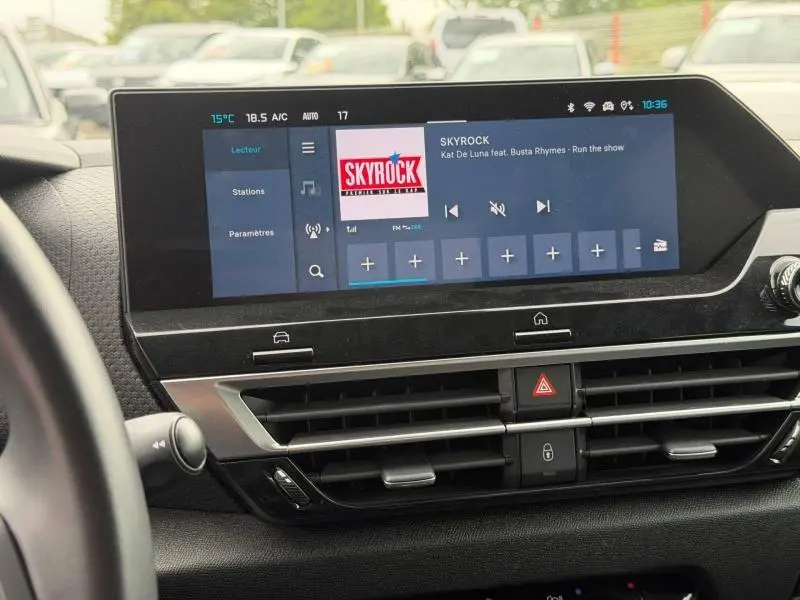 Écran tactile central du tableau de bord du Citroën C4 X 2024, affichant la radio Skyrock, avec commandes et aérateurs.