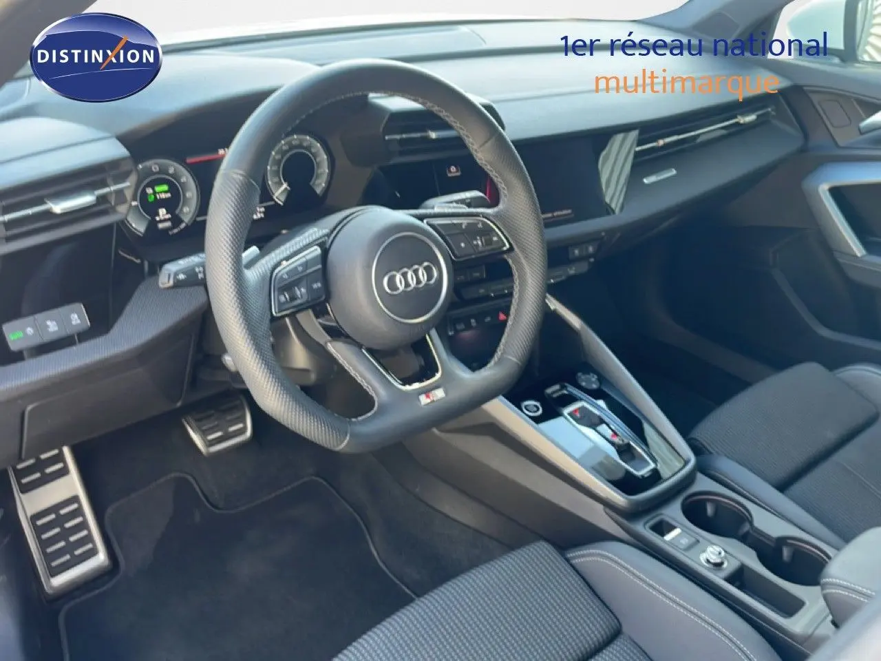 Vue intérieure côté conducteur de l'Audi A3 Sportback 2025, volant sport, tableau de bord numérique et sellerie tissu gris.