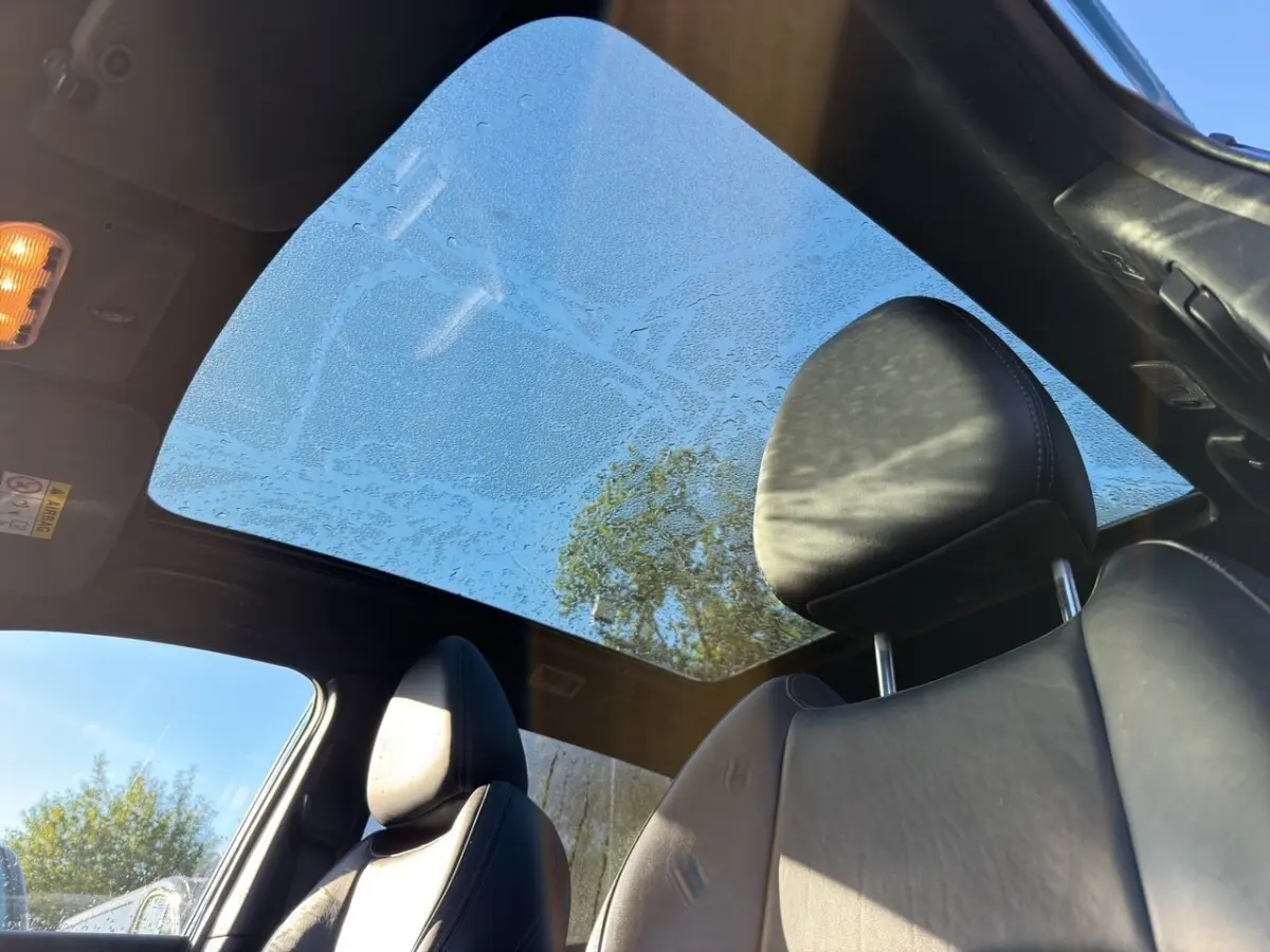 Vue intérieure du Nissan Qashqai Tekna+ 2018 montrant les sièges en cuir noirs et le toit panoramique en verre.
