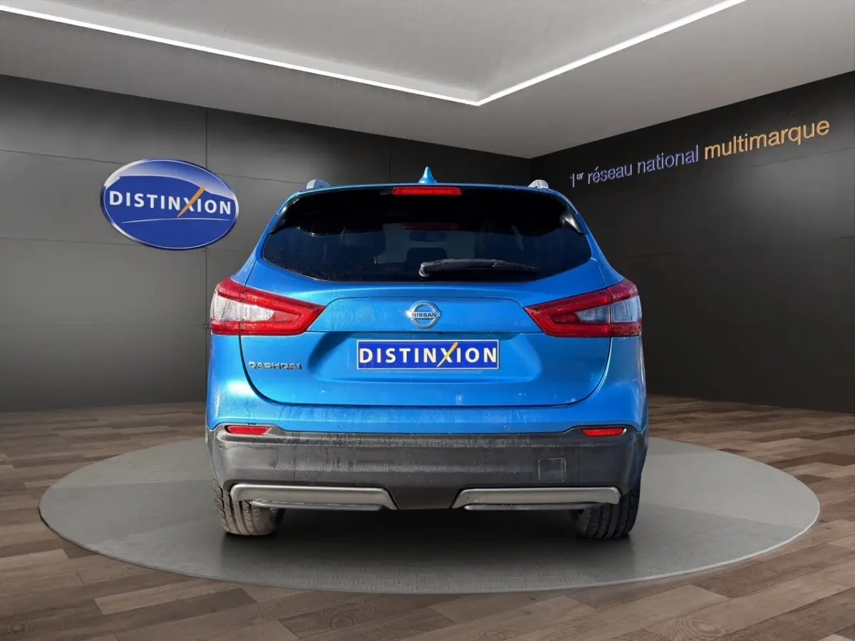 Vue arrière d'un Nissan Qashqai bleu 2018 avec feux arrière distinctifs et logo Nissan visible.