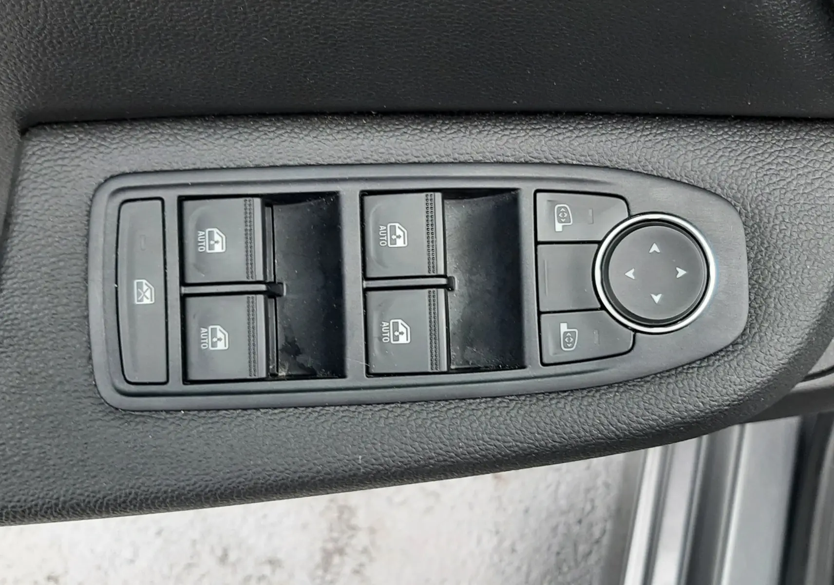 Panneau de commandes des vitres et rétroviseurs côté conducteur d'une Renault Clio V gris schiste, intérieur noir.