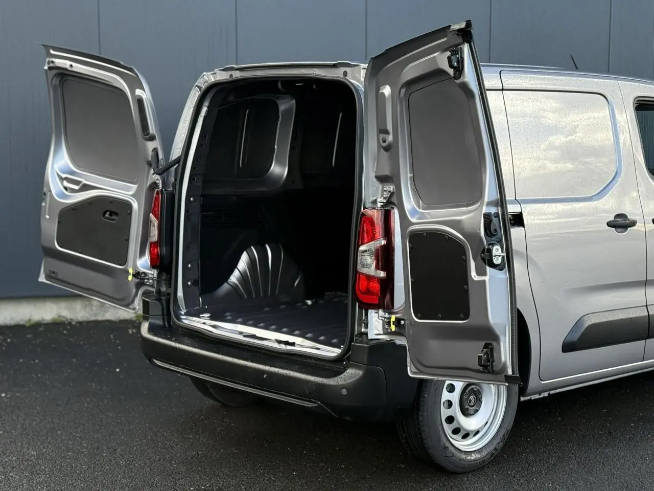 Vue arrière droite d'un Citroën Berlingo Van gris Artense avec portes arrière ouvertes et espace de chargement visible.