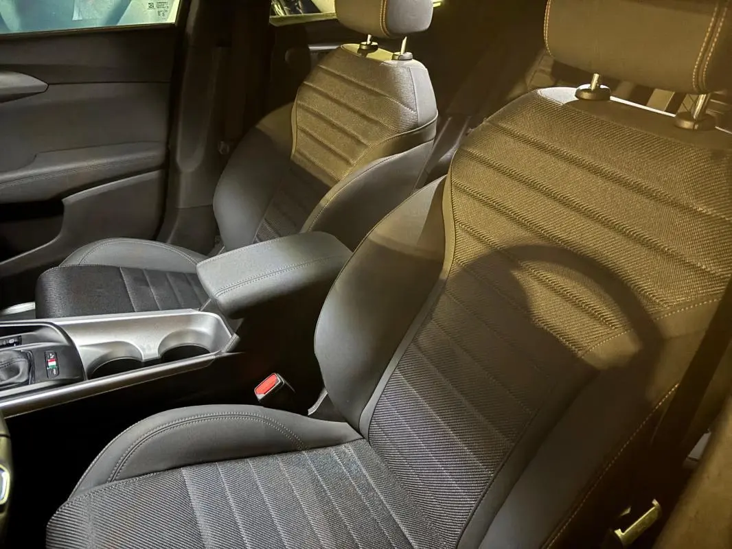 Vue intérieure rapprochée des sièges avant gris et de l'accoudoir central de l'Alfa Romeo Tonale 2023.