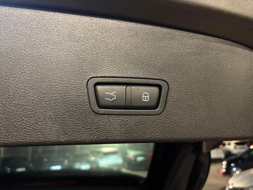 Gros plan sur les boutons de fermeture et verrouillage électrique du hayon intérieur d'un Alfa Romeo Tonale gris.