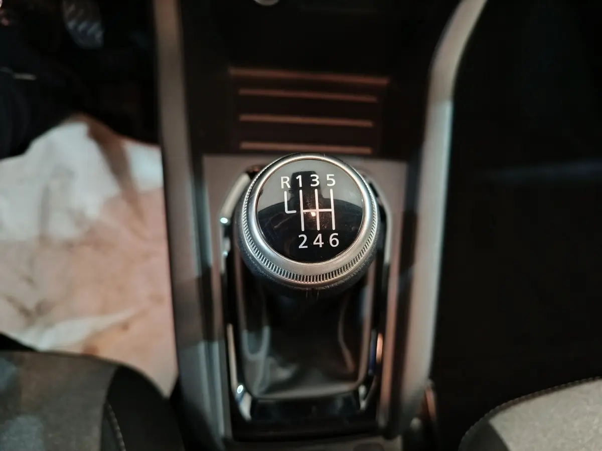 Gros plan sur le levier de vitesses manuel de la Renault Clio noire, affichant les six rapports et la marche arrière.