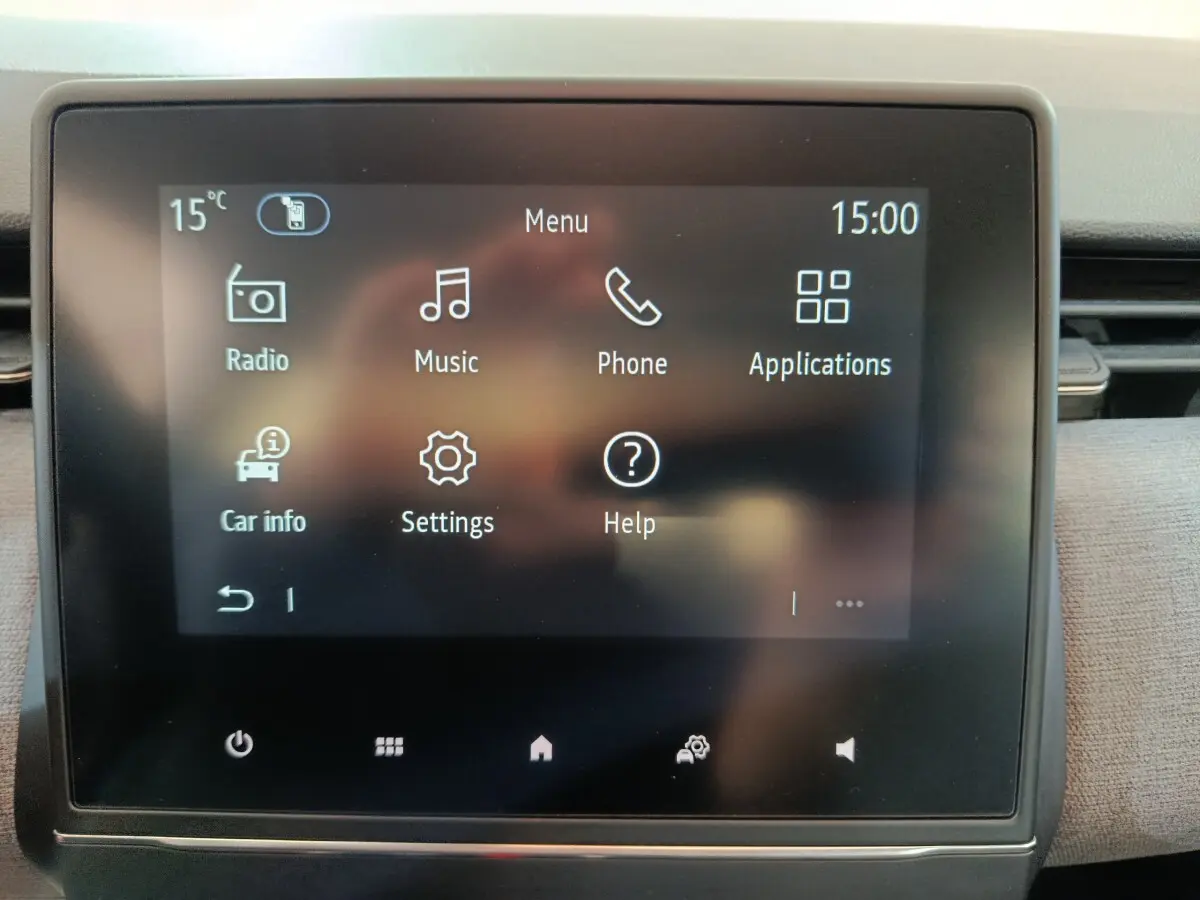 Écran tactile central de la Renault Clio noir affichant le menu principal avec options radio, musique, téléphone et applications.