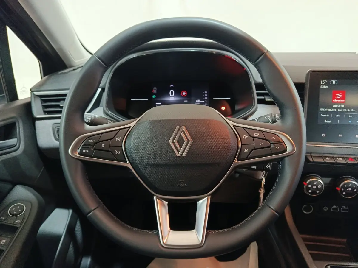 Vue centrée sur le volant cuir noir de la Renault Clio 2025 avec tableau de bord numérique et écran tactile latéral.