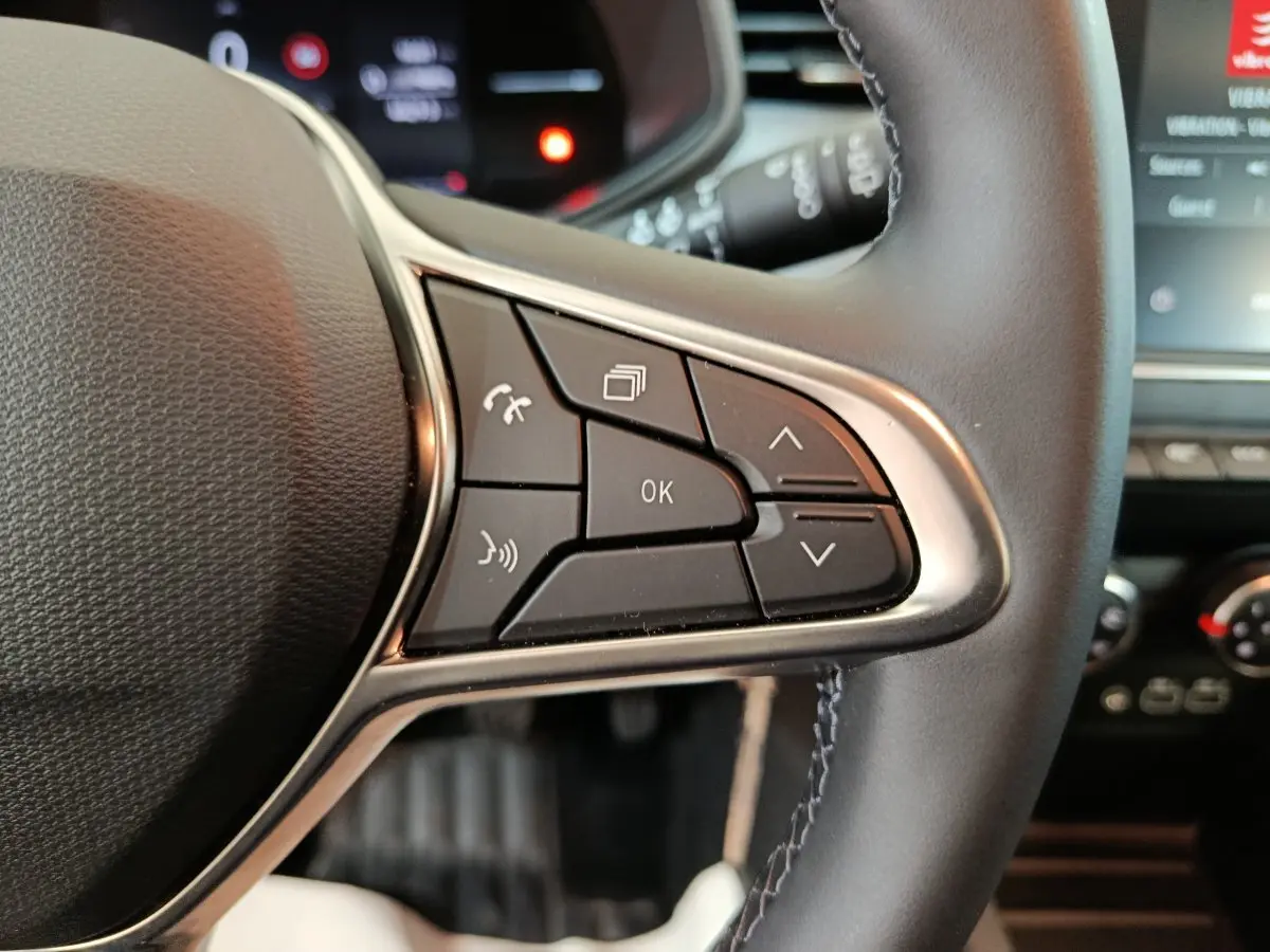 Gros plan sur les commandes multifonctions à droite du volant noir en cuir de la Renault Clio Evolution Blue dCi 100 2025.