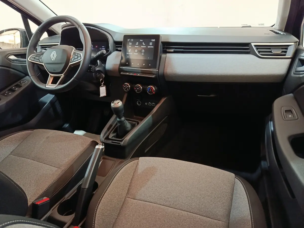 Vue intérieure côté conducteur de la Renault Clio Evolution Blue dCi 100 2025, tableau de bord gris et écran tactile central.