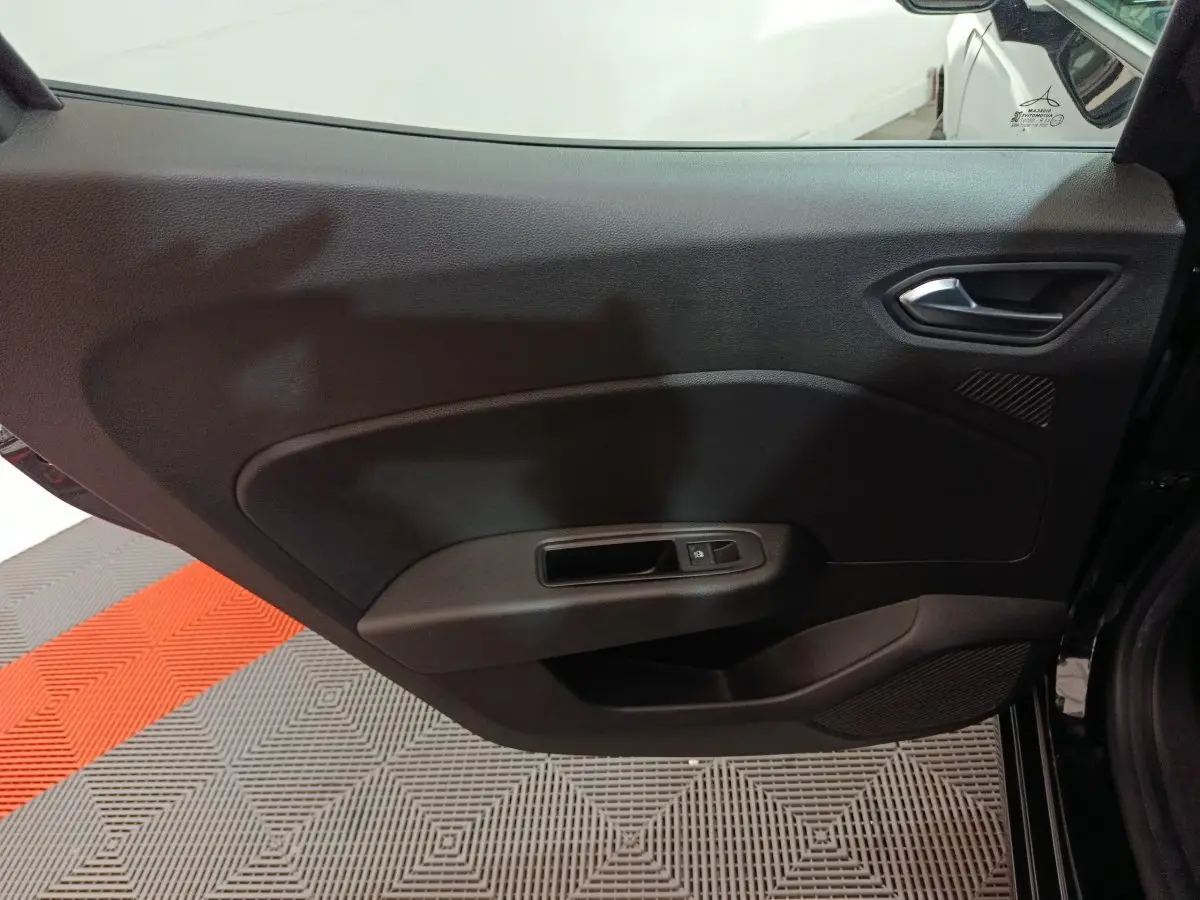 Vue intérieure de la porte arrière droite noire de la Renault Clio Evolution Blue dCi 100, avec poignée et commande de fenêtre.