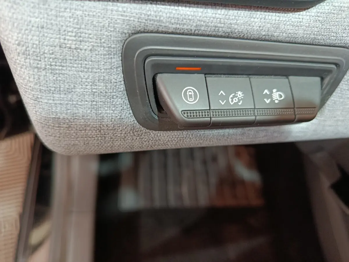 Détail des commandes d’éclairage et verrouillage sur tableau de bord tissu clair de Renault Clio noir 2025.