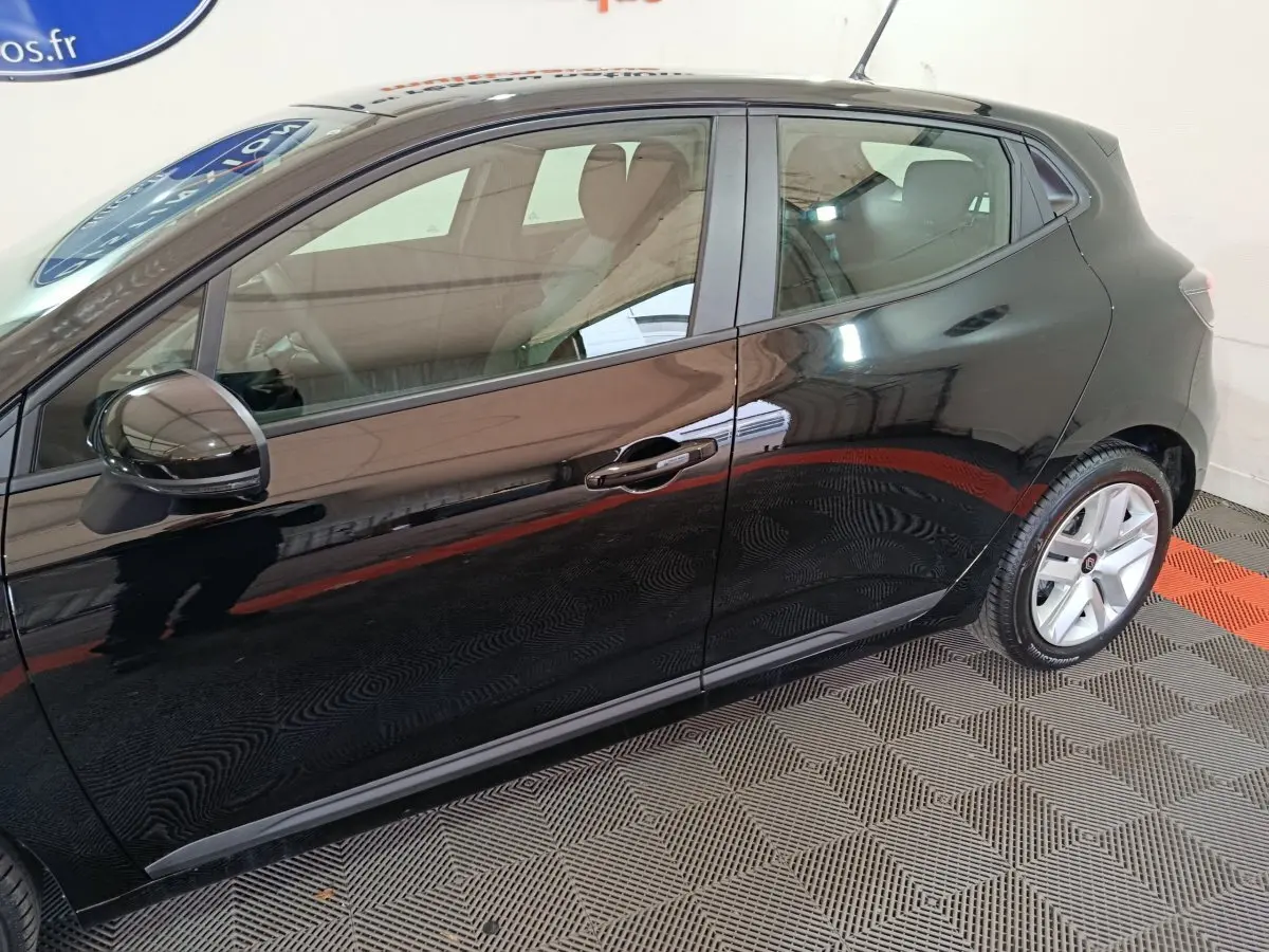 Vue latérale côté droit d'une Renault Clio noire Evolution Blue dCi 100, avec jantes alliage et rétroviseurs noirs brillants.