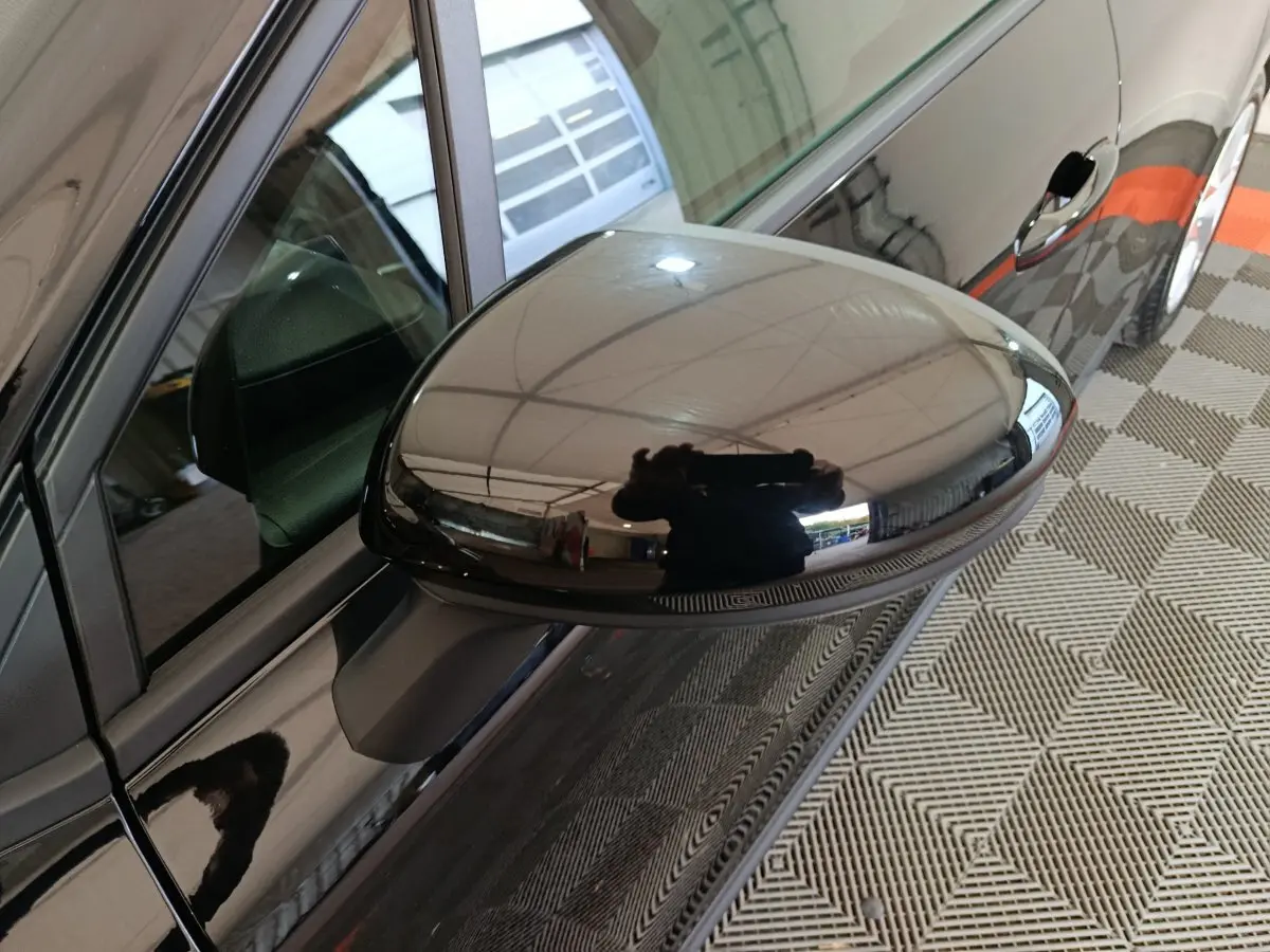 Rétroviseur côté conducteur noir brillant de la Renault Clio Evolution Blue dCi 100, vue rapprochée en intérieur.