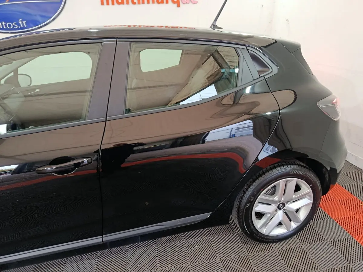 Vue latérale droite d'une Renault Clio noire 2025, mettant en valeur la porte arrière et la roue avec jante argentée.