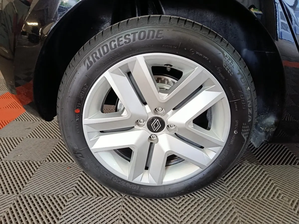 Gros plan sur la roue avant droite noire d'une Renault Clio 2025 avec jante argentée et pneu Bridgestone.