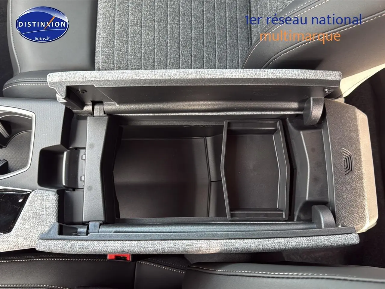 Vue plongeante sur l'accoudoir central gris titane ouvert du Peugeot 3008 1.2 hybrid 145 allure 2024.