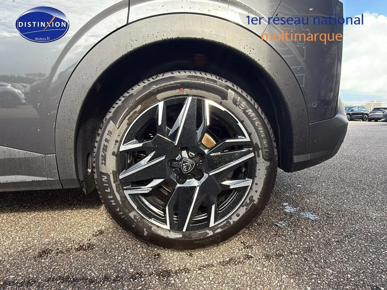 Gros plan sur la roue avant droite d’un Peugeot 3008 gris titane, jante alu noire et argentée au design moderne.