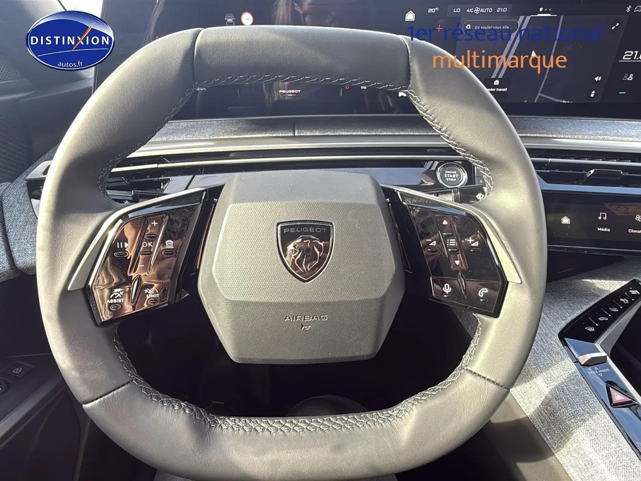 Vue rapprochée du volant cuir gris du Peugeot 3008 2024 avec commandes multifonctions et tableau de bord digital.