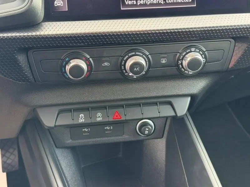 Gros plan sur la console centrale de l'Audi A1 Sportback 25 TFSI 95ch Advanced 2023, montrant les commandes de climatisation et les boutons de fonction.