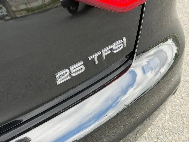 Gros plan sur l'arrière droit noir métallisé d'une Audi A1 Sportback 25 TFSI avec badge distinctif.