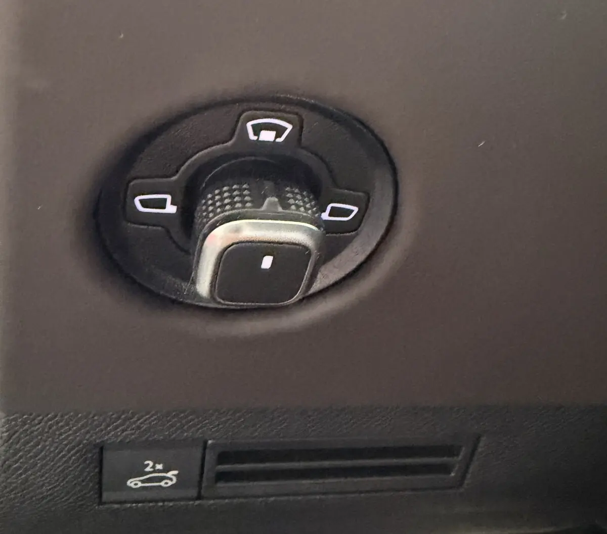 Gros plan sur la commande de réglage des rétroviseurs dans l’habitacle du DS4 blanc 2024, version BlueHDi 130 Etoile Nappa Auto.