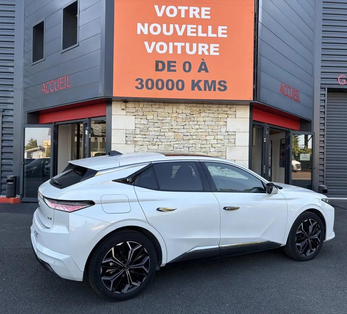 Vue côté droit arrière d'une DS4 blanche 2024 avec jantes noires et feux arrière LED au design distinctif.