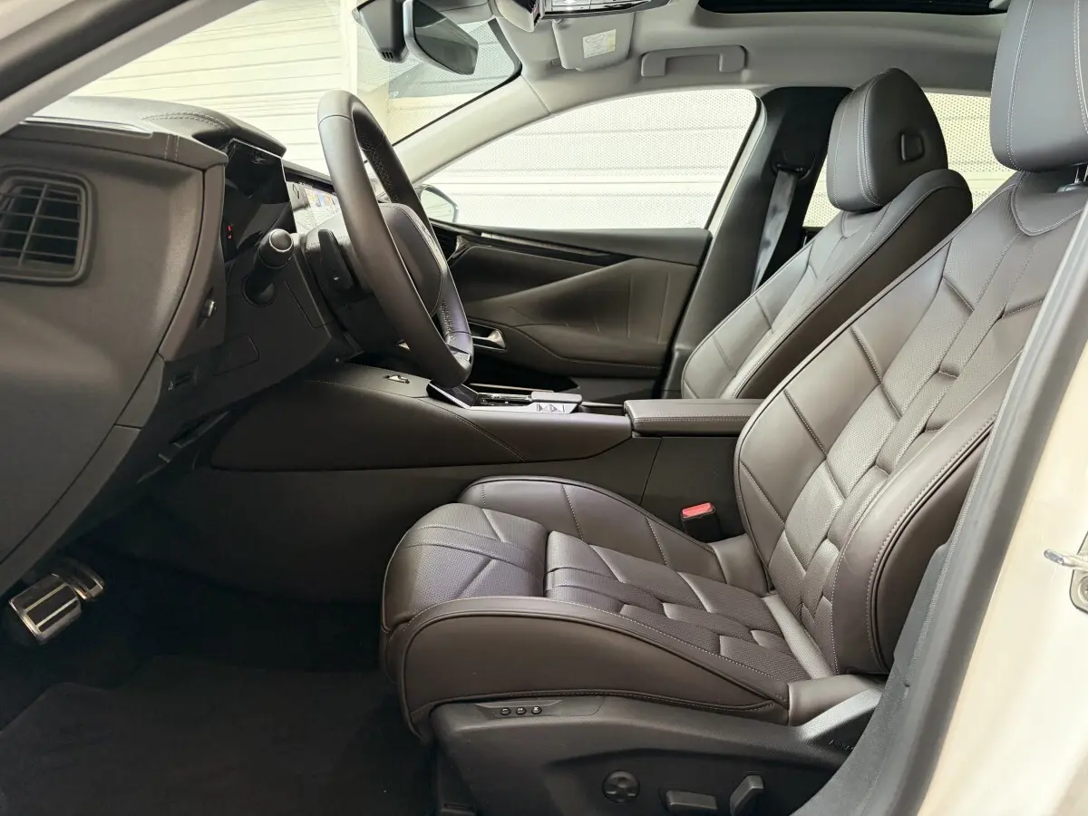 Vue intérieure côté conducteur du DS4 2024 blanc, sièges en cuir Nappa marron avec surpiqûres apparentes.