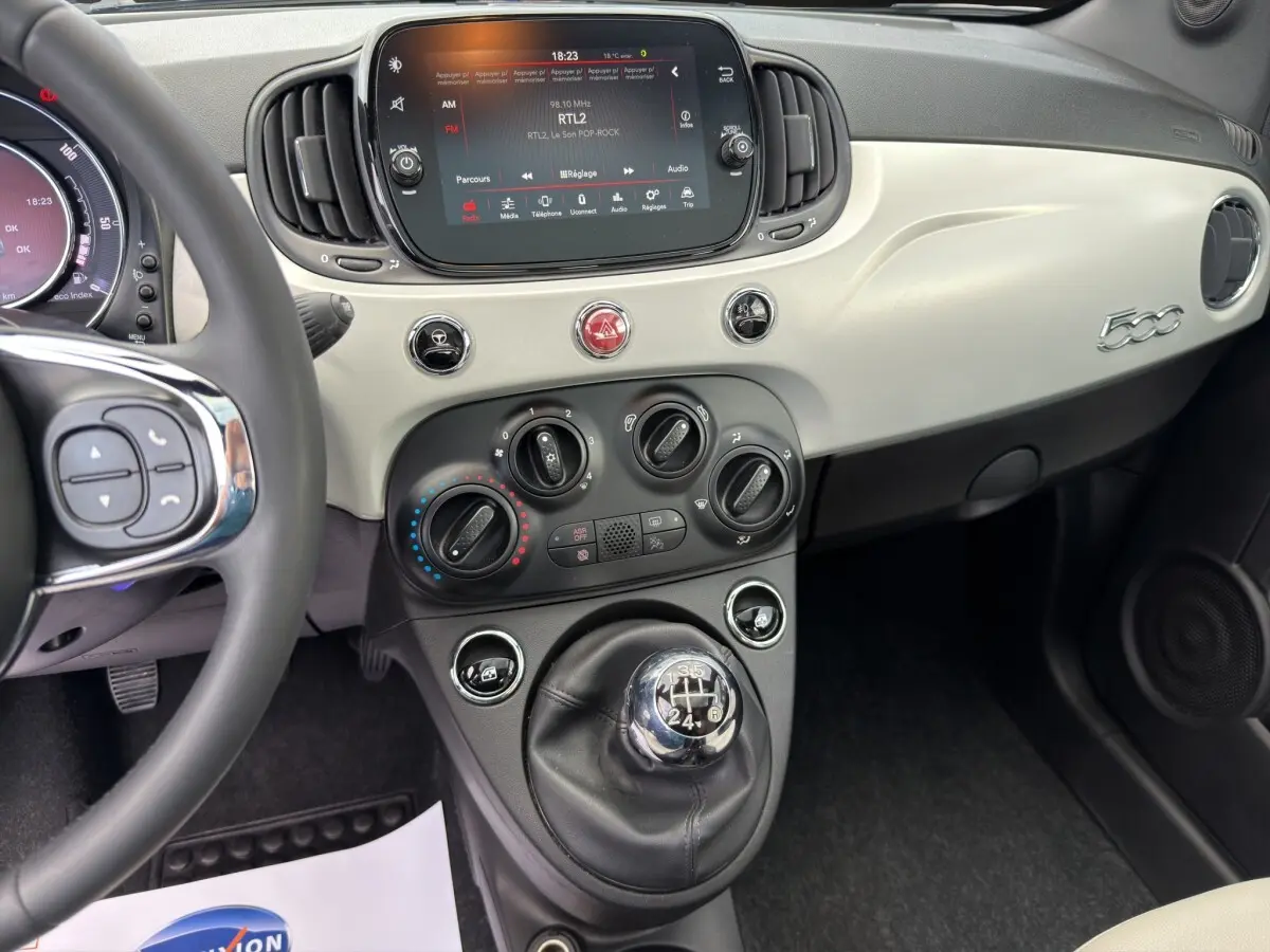 Vue intérieure de la Fiat 500 1.0 70ch BSG Star 2020, tableau de bord beige avec écran tactile et levier de vitesse manuel.