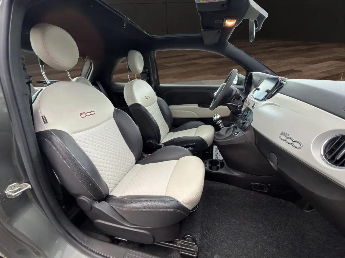 Intérieur de la Fiat 500 2020 vu côté gauche, sièges bicolores crème et noir avec logo 500 brodé.