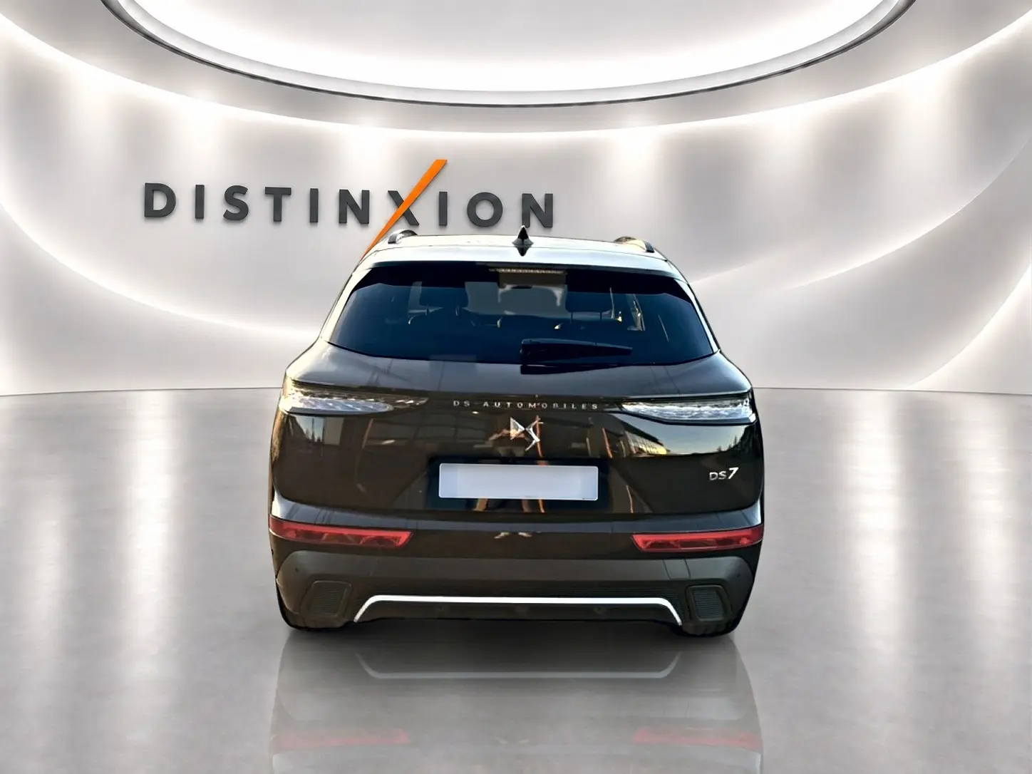 Vue arrière d'un DS7 noir 2026 avec feux LED étirés et double sortie d'échappement dans un showroom lumineux.
