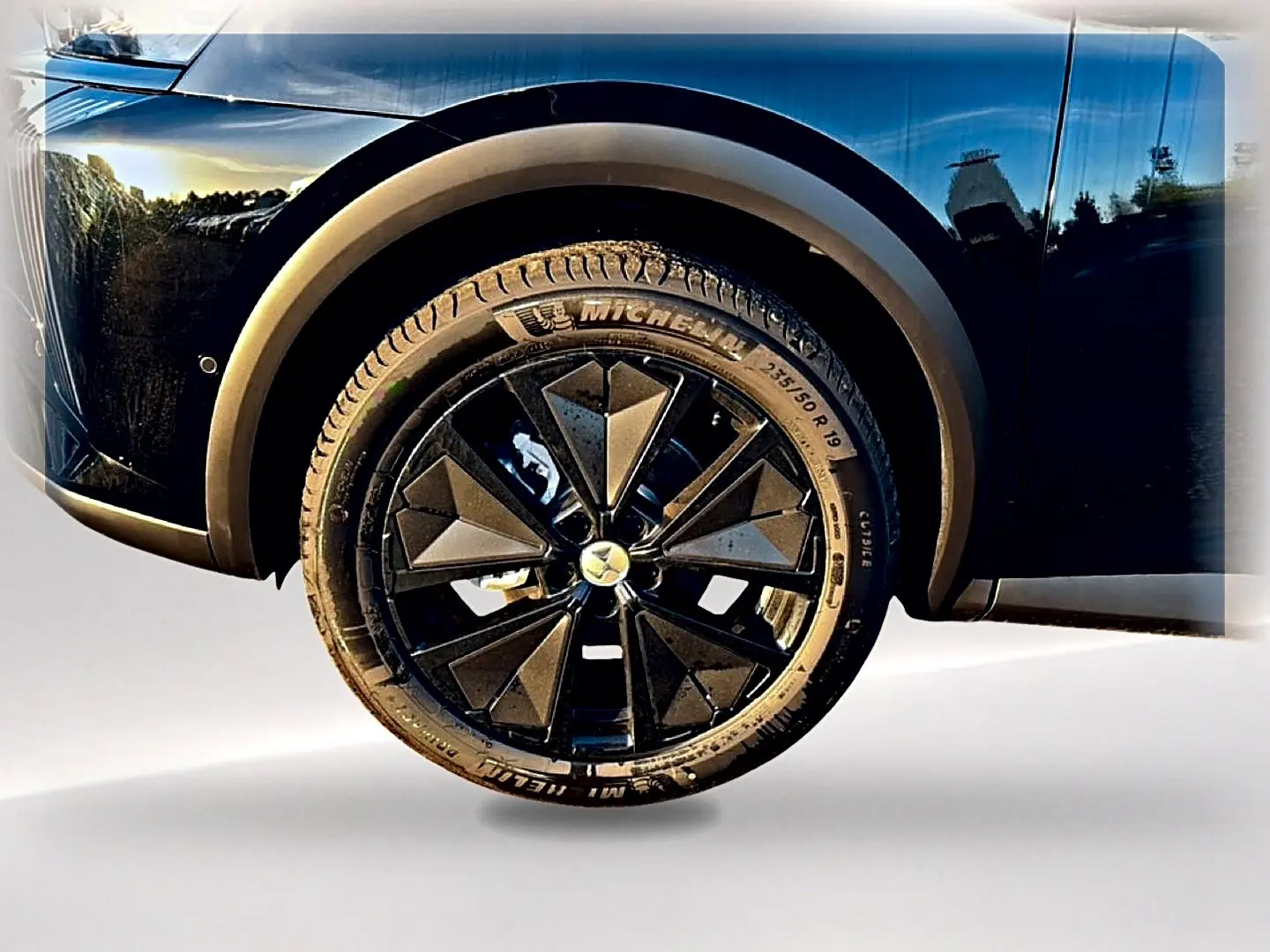 Gros plan sur la roue avant gauche noire du DS7 1.5 BlueHDi 130 avec jante alu noire au design géométrique.
