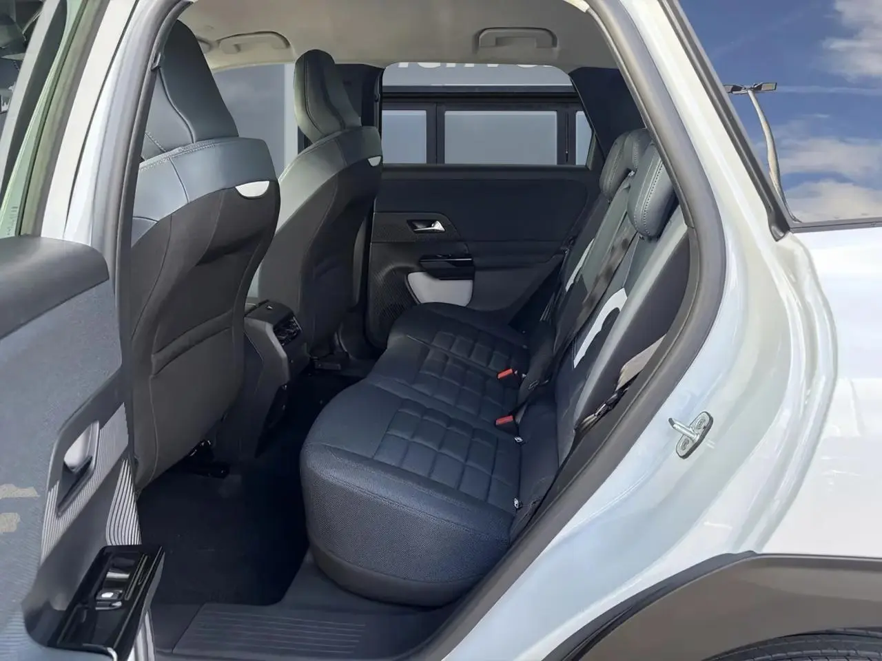 Vue intérieure côté droit des sièges arrière en tissu bleu du Citroën C5 Aircross blanc 2026.
