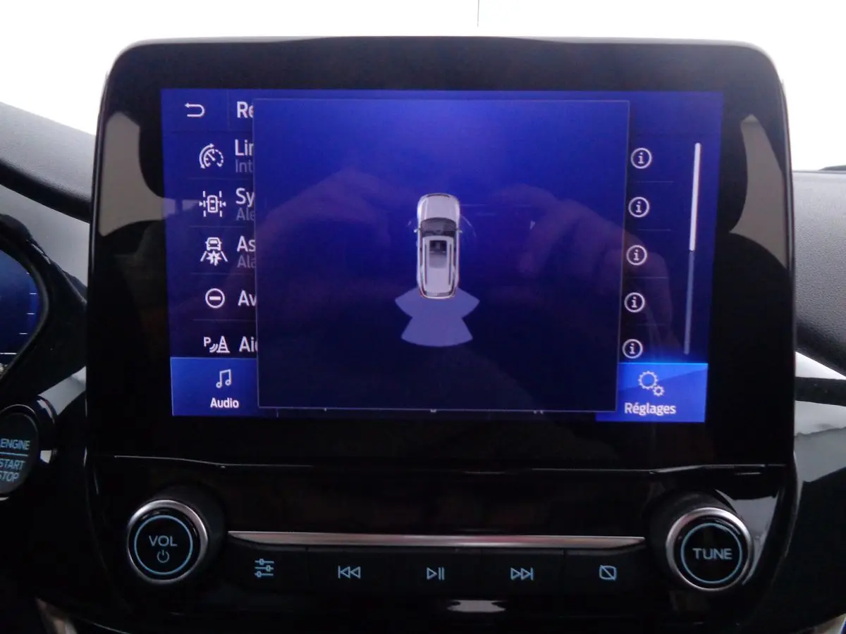 Écran tactile central du Ford Puma 2022 montrant l'assistance au stationnement avec commandes audio en dessous.