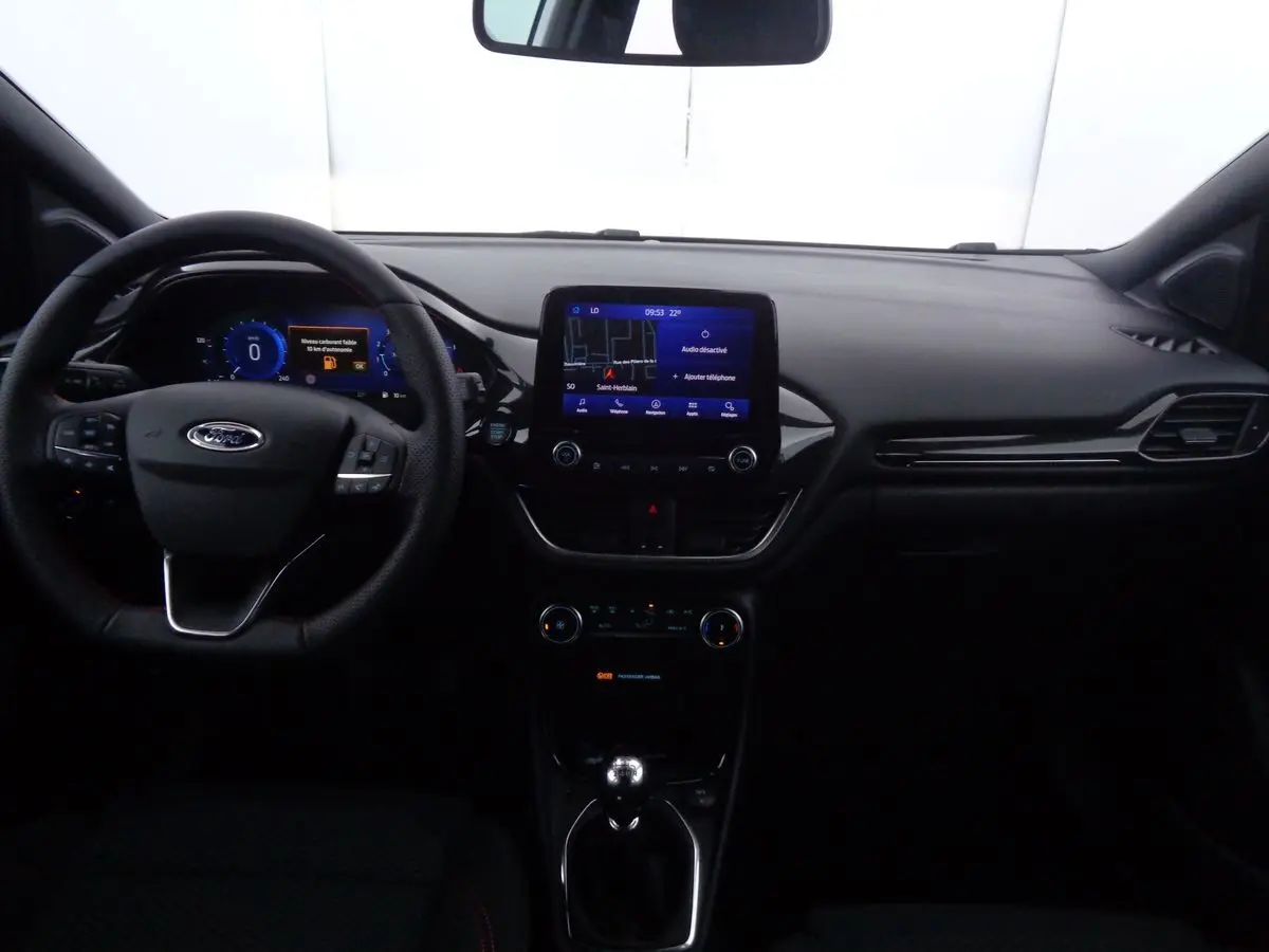 Vue intérieure avant du Ford Puma blanc 2022, tableau de bord moderne avec écran tactile et volant multifonction.