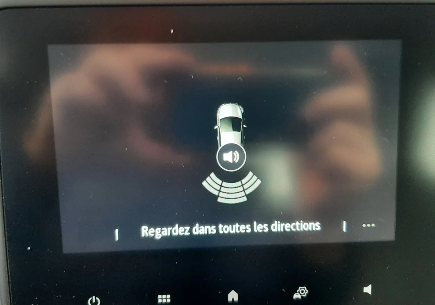 Écran central de la Renault Clio V gris schiste montrant l'alerte de détection d'obstacles avec signal sonore actif.