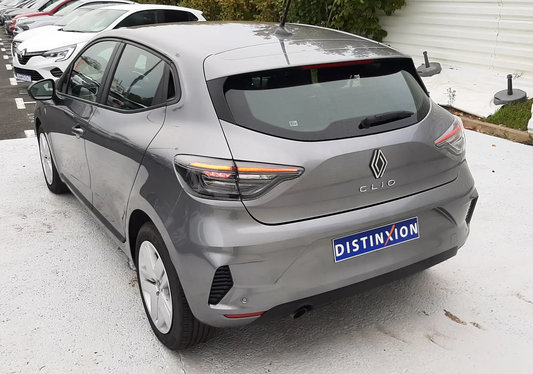 Vue 3/4 arrière droite d'une Renault Clio V gris schiste avec feux LED et plaque d'immatriculation Distinxion.