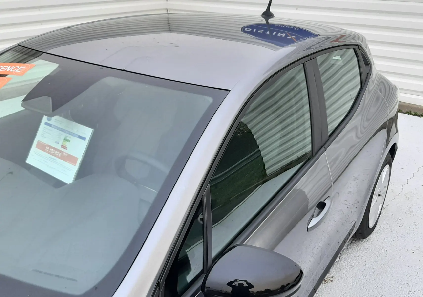 Vue plongeante côté droit sur une Renault Clio V gris schiste, mettant en valeur la carrosserie et les vitres teintées.