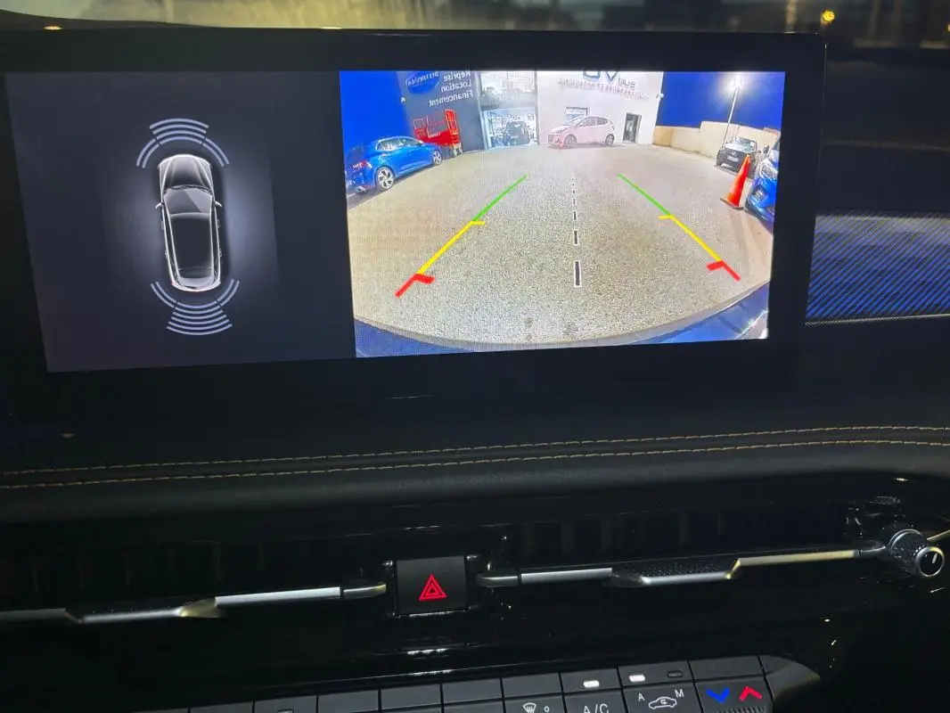 Écran intérieur montrant la caméra de recul et les capteurs de stationnement du tableau de bord d’un Alfa Romeo Tonale gris 2023.